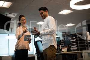 Business colleagues discussing on digital tablet at office