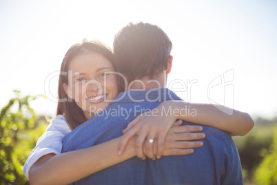 Happy woman hugging her boyfriend during sunny day