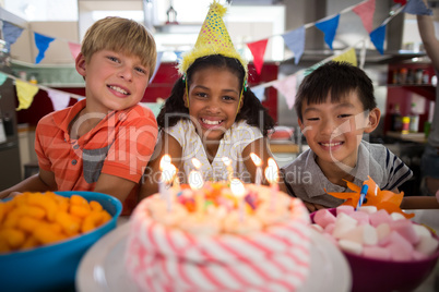 Portrait of siblings celebrating birthday in kitchen