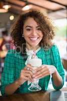 Portrait of smiling woman holding smoothie