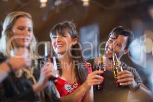 Smiling friends holding beer bottles