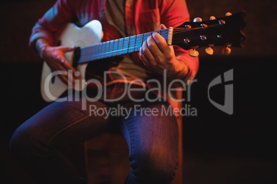 Mid-section of man playing guitar