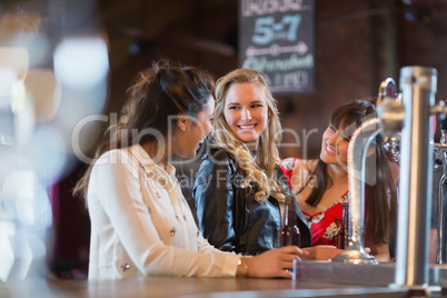 Smiling females standing by bar counter