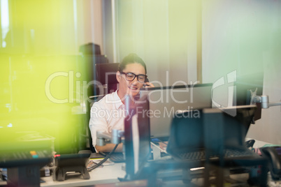 Smiling business executive talking on phone at office