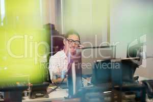 Smiling business executive talking on phone at office