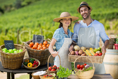 Smiling couple standing by fresh fruits and vegetables