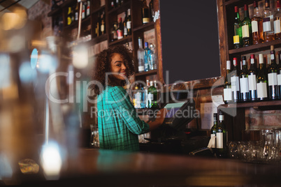 Portrait of beautiful female bar tender using electronic machine