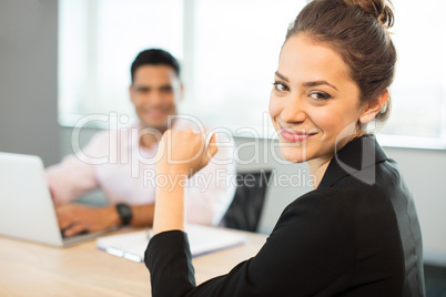 Portrait of smiling businesswoman sitting at table
