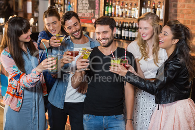 Happy friends toasting drink glasses