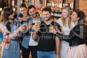 Happy friends toasting drink glasses