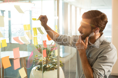 Thoughtful businessman analyzing adhesive notes