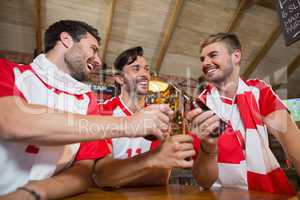 Cheerful male friends toasting beer bottles