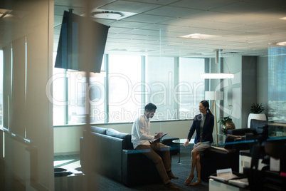 Businessman signing contract while sitting on sofa in office