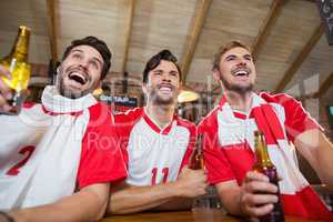 Cheerful friends holding beer bottles