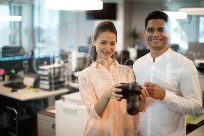 businesswoman holding camera with colleague