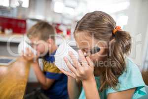 Sibling having breakfast cereal in kitchen