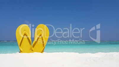 v02389 Maldives beautiful beach background white sandy tropical paradise island with blue sky sea water ocean 4k yellow flip flops