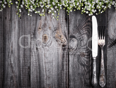 Cutlery on the gray wooden surface, empty space in the middle