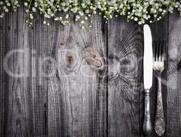 Cutlery on the gray wooden surface, empty space in the middle