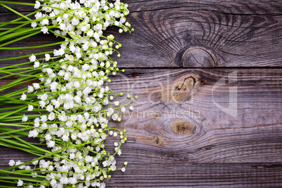 Wooden gray background with fresh flowers lilies of the valley