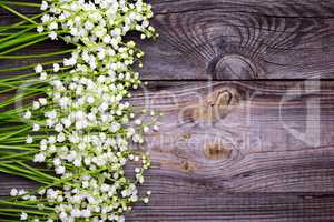 Wooden gray background with fresh flowers lilies of the valley