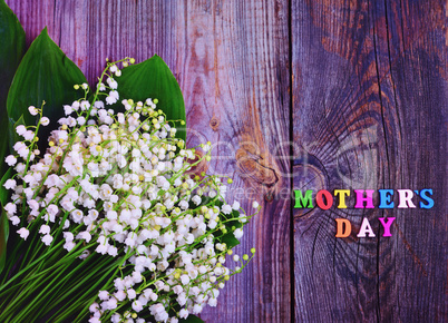 Festive gray wooden background with the inscription Mother's Day