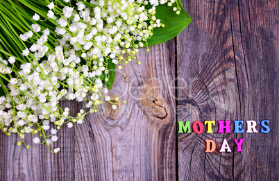 Gray wooden background with the inscription Mother's Day