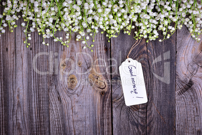 Gray wooden background with a paper tag with the inscription goo