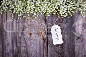 Gray wooden background with a paper tag with the inscription goo