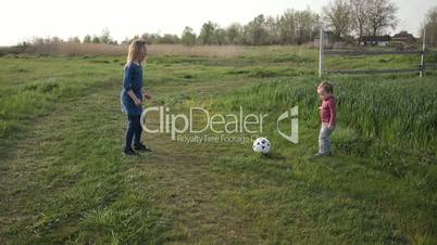 Cute siblings playing football together outdoor
