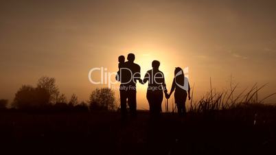 Silhouettes of grandparents with kids at sunset