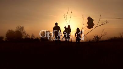 Silhouettes of happy family watching sunset