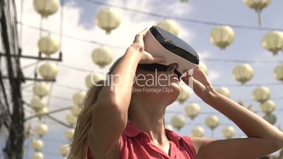 Woman uses virtual reality glasses outdoors