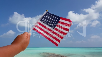 v01099 Maldives beautiful beach background white sandy tropical paradise island with blue sky sea water ocean 4k hand holding us american flag