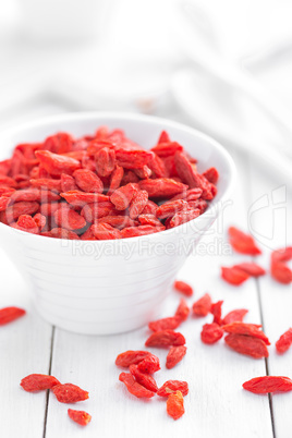 Goji berries in bowl on white background