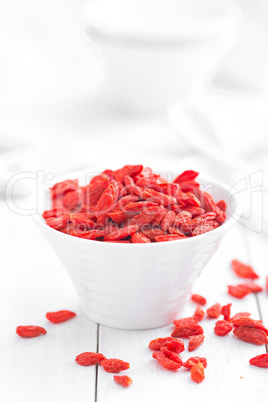 Goji berries in bowl on white background