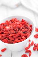 Goji berries in bowl on white background