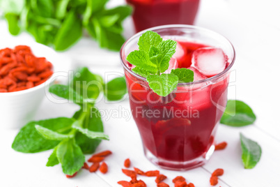 Healthy detox drink with goji berries infused in water with ice, cold refreshing beverage