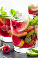 Raspberry mojito cocktail with lime, mint and ice, cold, iced refreshing drink or beverage