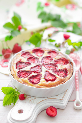 Delicious strawberry tart or cheesecake with fresh berries and cream cheese, closeup on white wooden rustic background