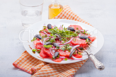 Grapefruit salad with olives, red onion and basil