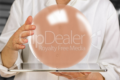 Woman holding tablet pc with glass ball