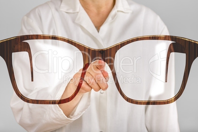 Person pointing with finger at glasses
