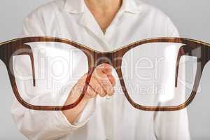 Person pointing with finger at glasses