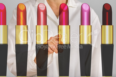 Person pointing with finger on lipsticks