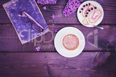 Coffee in a white cup with a saucer and a biscuit cake on a wood