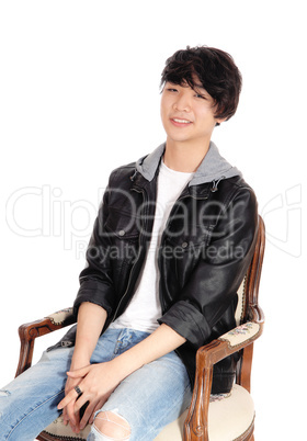 Asian teenager sitting in old armchair.