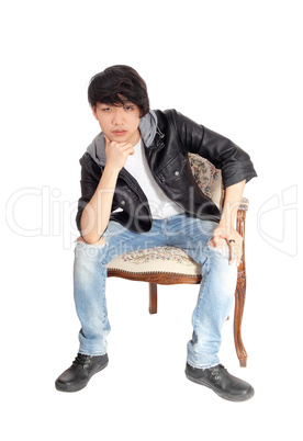 Asian teenager sitting in chair.