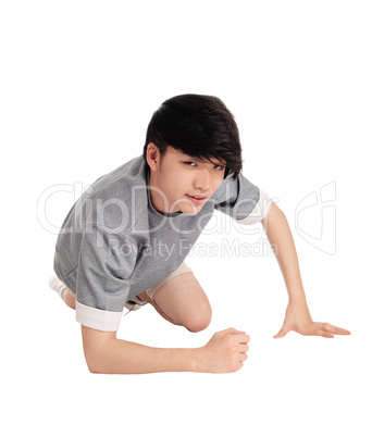 Asian man kneeling on floor.