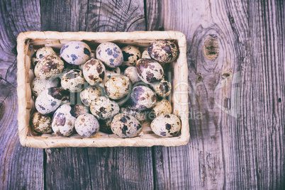 Raw quail eggs in a wicker basket, top view